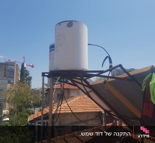 דוד שמש על גג עם קולטים ומערכת צינורות